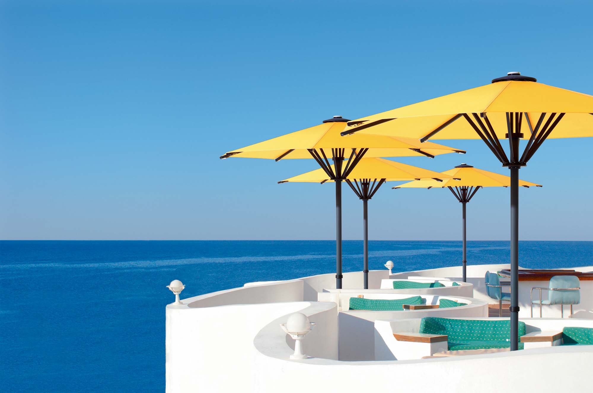 Sonnenschirm Bahama Pure auf Einer Terasse direkt am türkisen Meer.